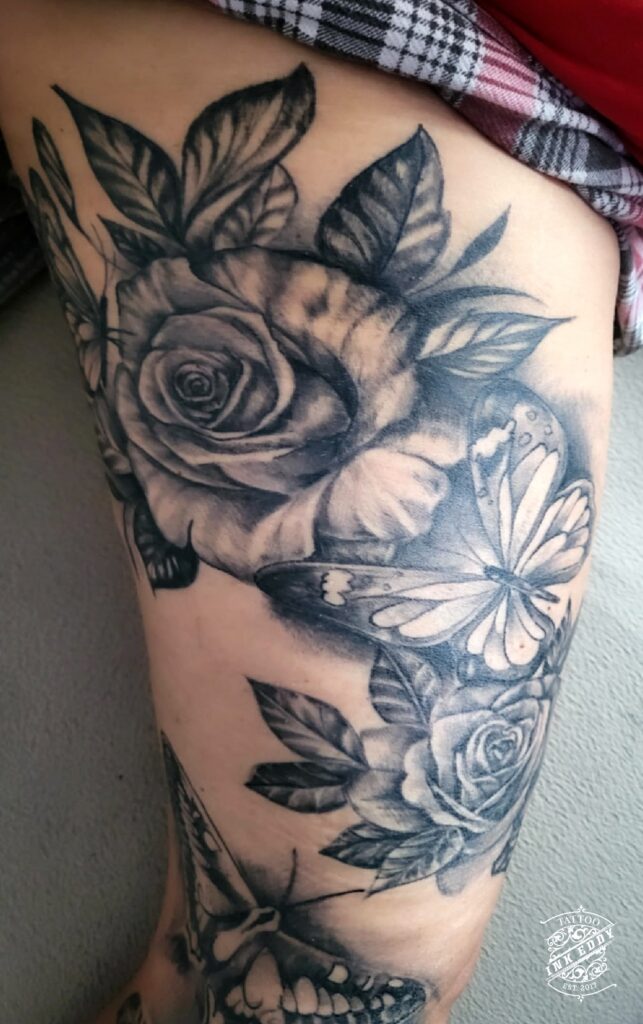 Parantunut ruusu ja perhonen tatuointi black and grey tyylillä